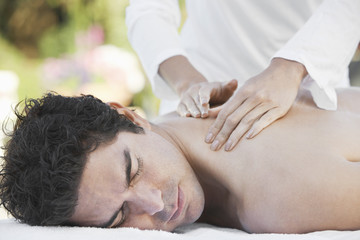Fototapeta na wymiar Mature man receiving shoulder message from a female masseur