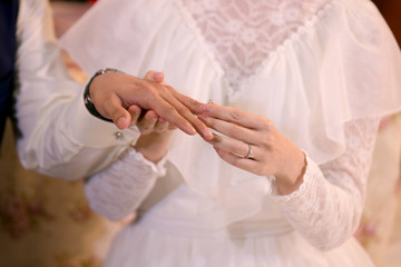 Obraz na płótnie Canvas Groom wears wedding ring. Bride wearing wedding ring