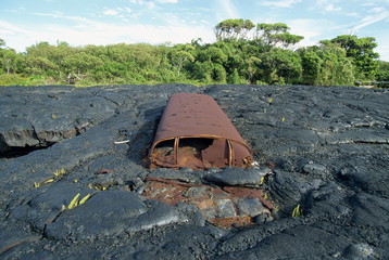 School bus near Kaimu buried in the 1988 basalt lava flows that covered a large area of the south east Puna coast and cut highway 130, Big Island, Hawaii