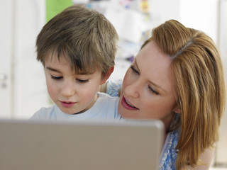 Young woman and son using laptop at home