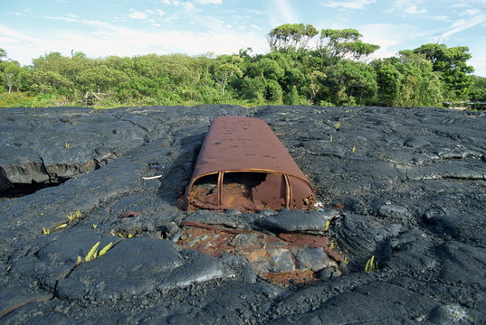 School bus near Kaimu buried in the 1988 basalt lava flows that covered a large area of the south east Puna coast and cut highway 130, Big Island, Hawaii