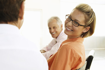 Fototapeta premium Smiling young businesswoman with male colleagues in conference room