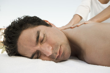 Fototapeta na wymiar Hispanic mature man receiving back massage at spa