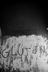 gluten word written in wheat flour on dark board