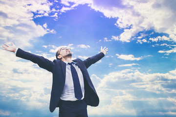 businessman celebrates freedom success arms raised looking up to