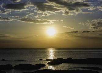 Fototapeta premium Rocks on the beach with sunset sky low key silhoette.