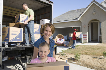 Happy family with cardboard boxes moving into new house