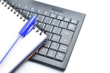 A notepad and keyboard of a computer. write down and save