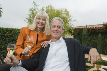 Portrait of a middle aged couple with wine glasses in the garden