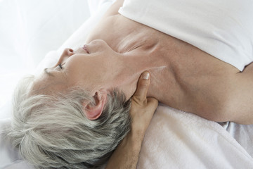 High angle view of a senior woman receiving neck massage at spa
