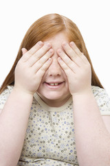 Happy teenage girl covering her eyes isolated over white background