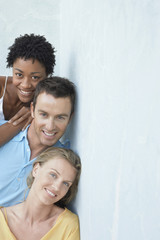 Portrait of happy young multiethnic friends leaning against wall