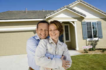Portrait of a happy mature couple embracing in front of new house
