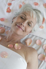 High angle view of a senior woman lying on massage table at spa