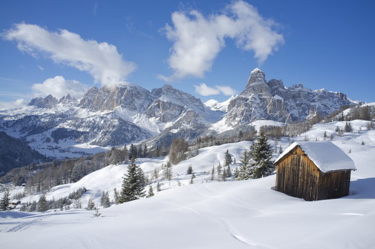 Mounts Lavarella, Conturines and Sasongher behind a snow covered wooden barn at the Alta Badia ski resort, Corvara, Dolomites, South Tyroll 