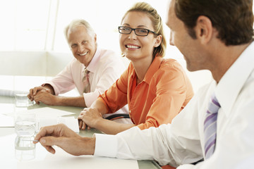 Portrait of happy businesswoman with colleagues in conference room