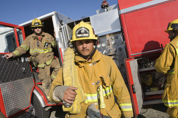 Portrait of a mature fire worker with coworkers in the background