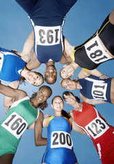Fototapeta premium Directly below shot of multiethnic female athletes forming huddle against sky