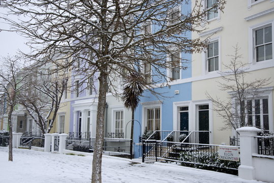 Pastel coloured houses on a snowy day in Elgin Crescent in the Notting Hill area of London