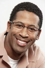 Close-up portrait of an African American man smiling over white background