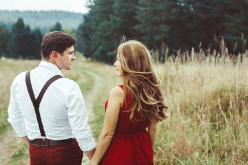 the lovers are standing on a forest road