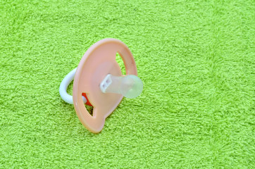 Pacifier on the green towel