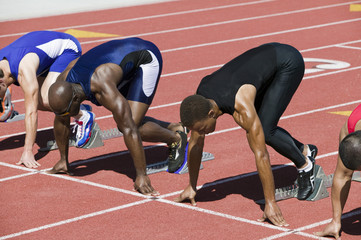 Multiethnic male athletes at starting line in track race