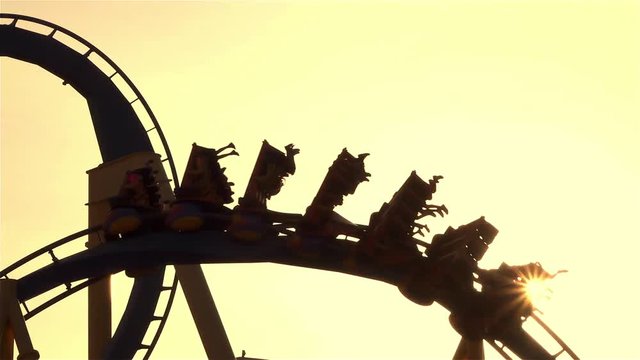 CLOSE UP: Friends on extreme roller coaster ride at sunset