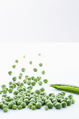 Fresh green peas with empty pea pod over white background