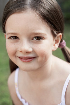 Closeup portrait of smiling young girl in park