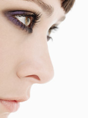 Closeup side view of a beautiful young woman wearing heavy eye makeup