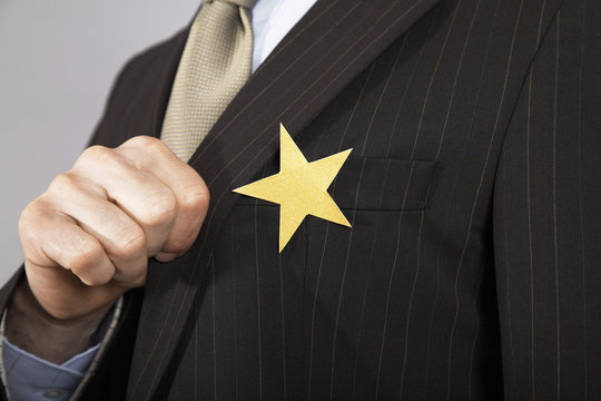 Extreme closeup of a businessman with gold star on suit