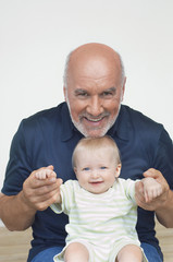 Portrait of a cheerful mature grandfather playing with grandson