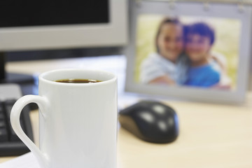 Coffee mug on table with family photo in background