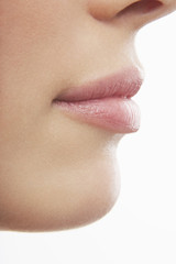 Detailed shot of young woman's lips on while background