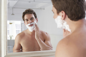 Closeup of a young man applying shaving cream