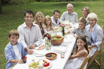Portrait of three generation family dining together in garden