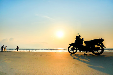 Obraz premium Motorbike Silhouette a motorbike stands on the beach