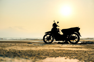 Obraz na płótnie Canvas Motorbike Silhouette a motorbike stands on the beach