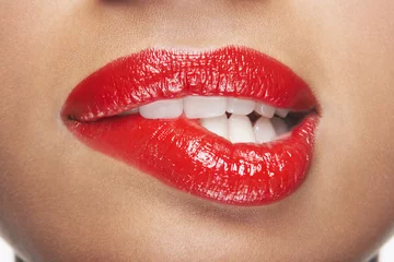 Poster Closeup of sensuous woman biting red lips © moodboard