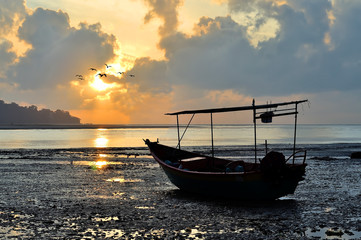 Fishing boat on the beach when sun rising up