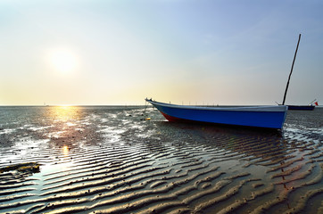 Fishing boat on the beach when sun rising up