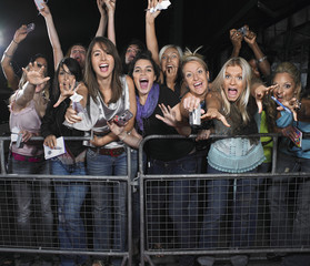 Fans leaning over barrier and screaming