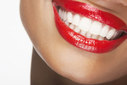 Detailed image of beautiful woman smiling with red lips on white background