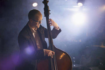Man playing the double bass on stage - obrazy, fototapety, plakaty