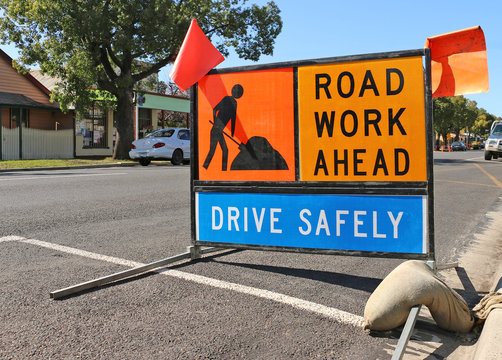brightly coloured road work ahead signs