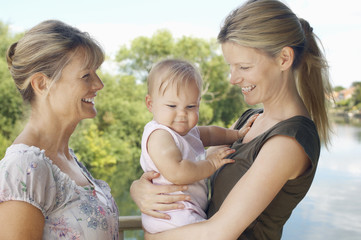 Grandmother with mother and daughter against the lake