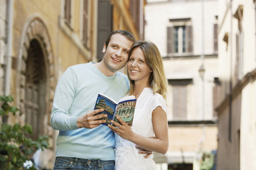 Young couple holding guidebook on street in Rome, Italy