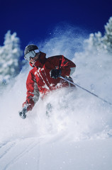 Skier skiing in powder snow against clear sky