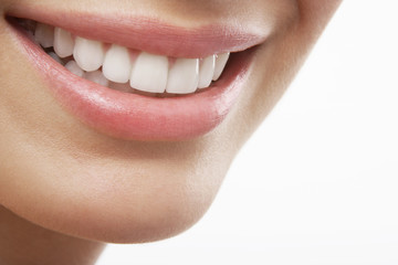 Closeup of woman smiling with prefect white teeth on white background
